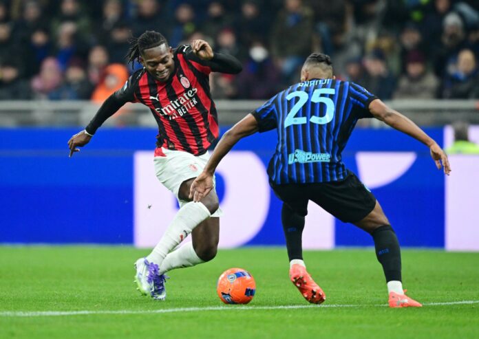 Pemain AC Milan berseragam merah hitam menggiring bola saat dihadang pemain Inter Milan berseragam biru hitam di lapangan.