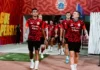 Dua Bek Bawa Persija Menang 2-1 atas Persik Kediri Para pemain Persija mengenakan seragam latihan merah berjalan keluar dari lorong stadion