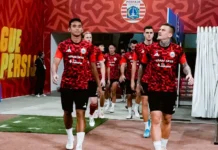 Dua Bek Bawa Persija Menang 2-1 atas Persik Kediri Para pemain Persija mengenakan seragam latihan merah berjalan keluar dari lorong stadion