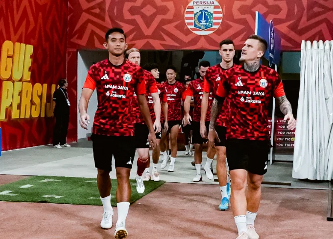 Persija-Menang-2-1-atas-Persik-Kediri Para pemain Persija mengenakan seragam latihan merah berjalan keluar dari lorong stadion