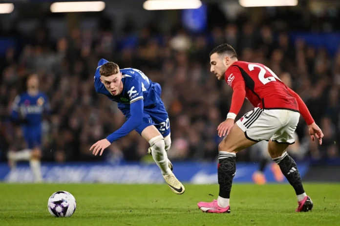Pemain Chelsea berseragam biru dan pemain Manchester United berseragam merah mengejar bola dalam pertandingan.