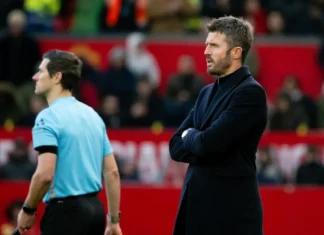 Manchester United Terpuruk, Pertahanan Rapuh dan Serangan Tumpul Michael Carrick berdiri dengan tangan terlipat di tepi lapangan