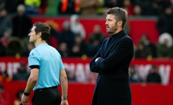 Screenshot-2026-10-26-183754 Michael Carrick berdiri dengan tangan terlipat di tepi lapangan