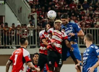 Persib Jamu Melbourne Victory, Puncak Grup E Jadi Taruhan Sejumlah pemain sepak bola berseragam biru dan merah putih berebut bola udara di lapangan