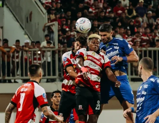 Persib Jamu Melbourne Victory, Puncak Grup E Jadi Taruhan Sejumlah pemain sepak bola berseragam biru dan merah putih berebut bola udara di lapangan