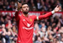 AC Milan Pantau Bruno Fernandes, Gaji Tinggi Jadi Kendala Pemain Manchester United berseragam merah mengangkat kedua tangan di lapangan