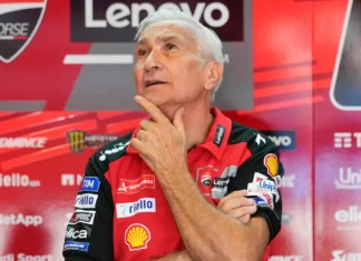 Ducati Akui Tiga Seri Terakhir Lebih Cocok untuk Aprilia Pria berambut putih mengenakan seragam merah Ducati Lenovo Team di area tim balap