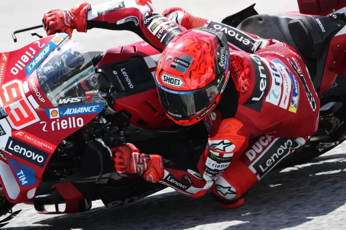 Marc Marquez Menikung dengan Motor Ducati Lenovo Pembalap Ducati Lenovo dengan helm merah dan nomor motor 93 memiringkan motor balap merah saat melewati tikungan.